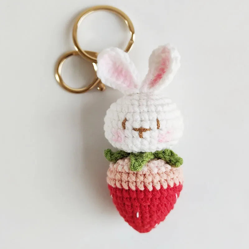 White hand-woven wire pendant charm with a cartoon rabbit and strawberry design on a key hook.