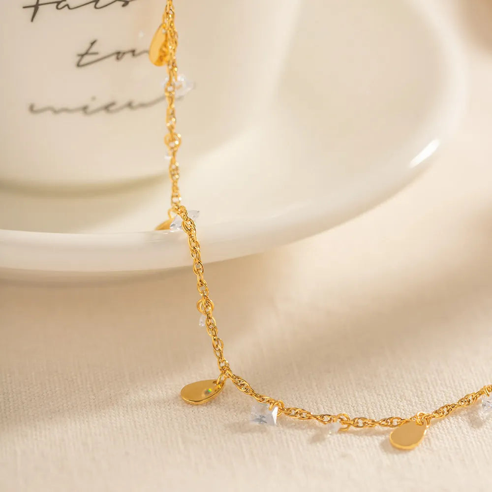 Silver-tone stainless steel anklet with a geometric water drop tassel charm on an adjustable chain.