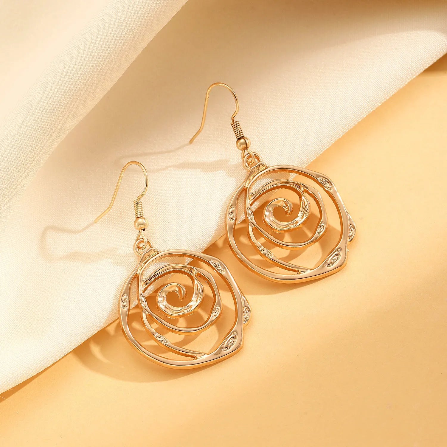 Women's spiral donut jewellery set showing necklace, bracelet and earrings in gold finish