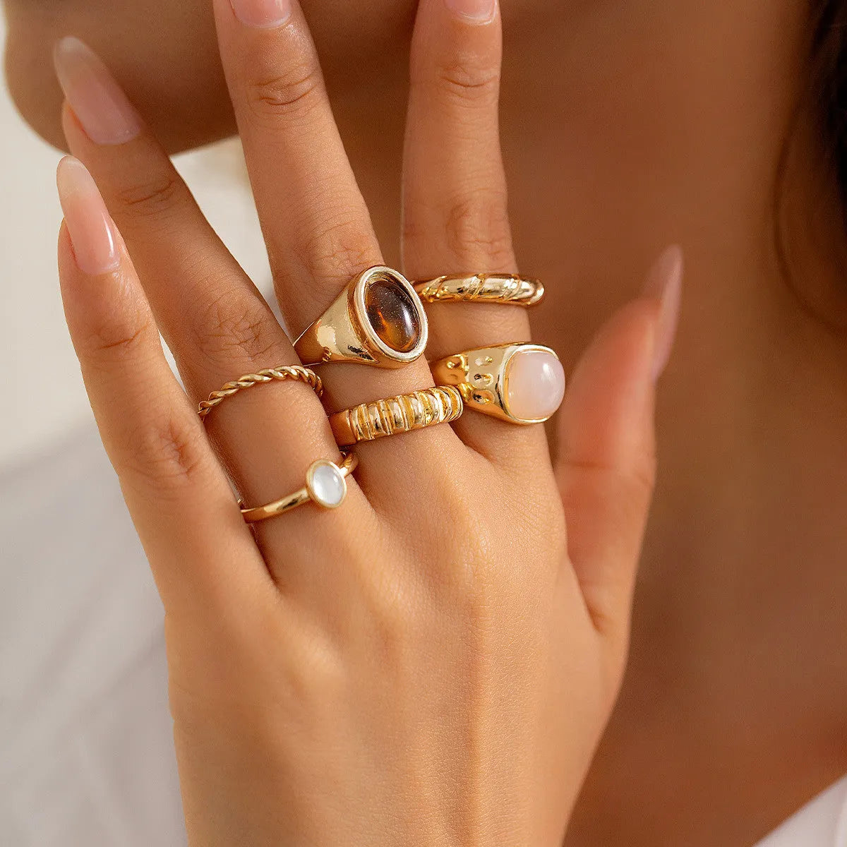 Set of six light gold geometric and round alloy stacking rings arranged together