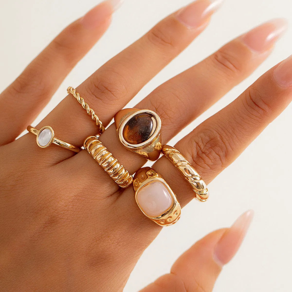 Set of six light gold geometric and round alloy stacking rings arranged together