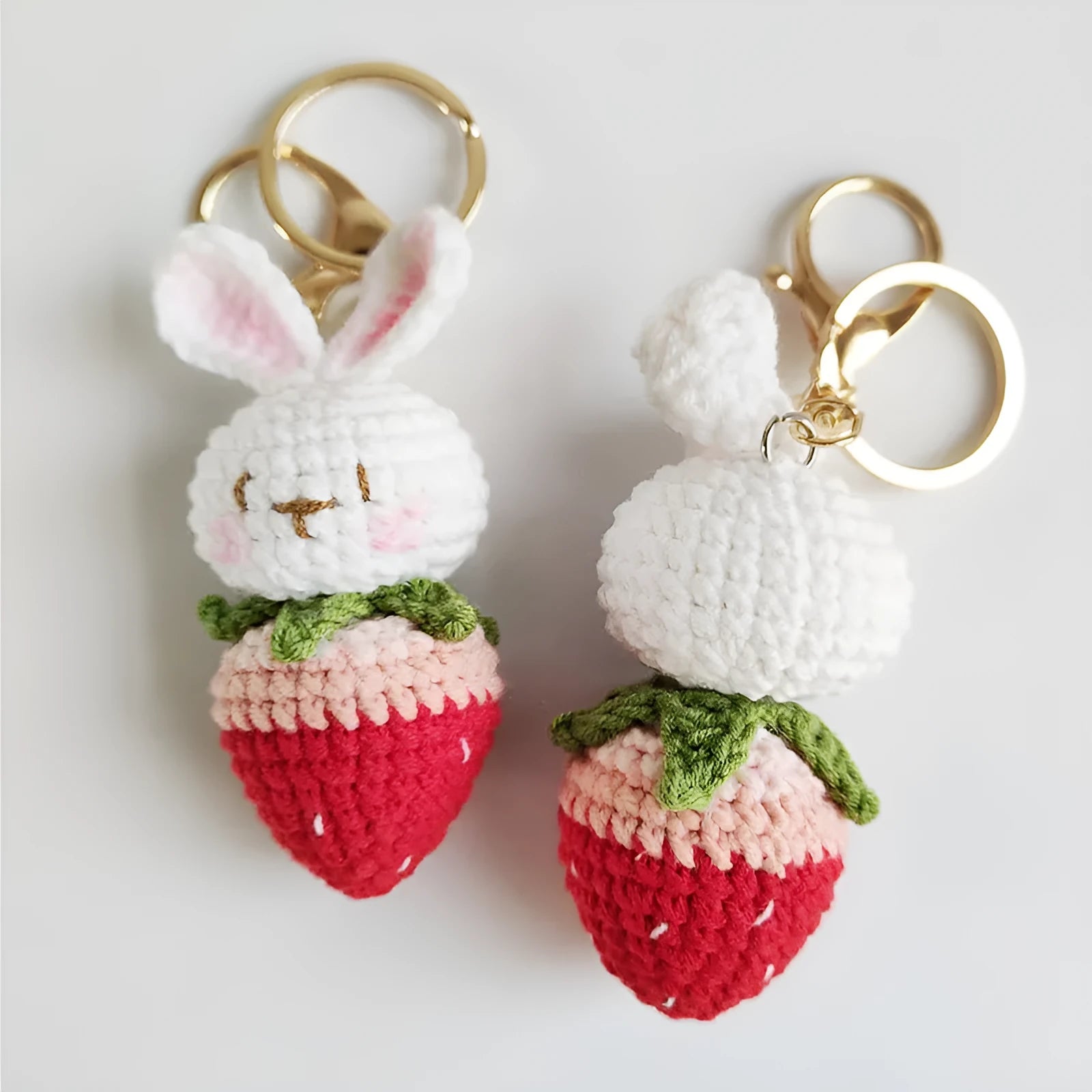 White hand-woven wire pendant charm with a cartoon rabbit and strawberry design on a key hook.
