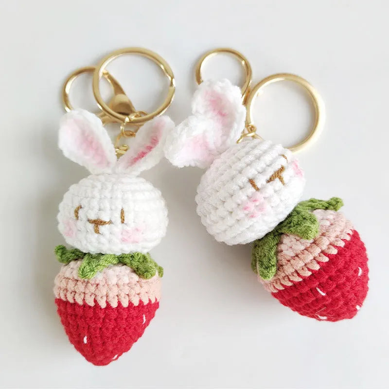 White hand-woven wire pendant charm with a cartoon rabbit and strawberry design on a key hook.