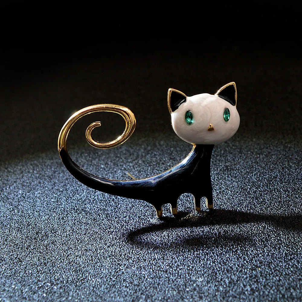 Close-up of an orange painted cat tail brooch made from alloy metal with a pin clasp.