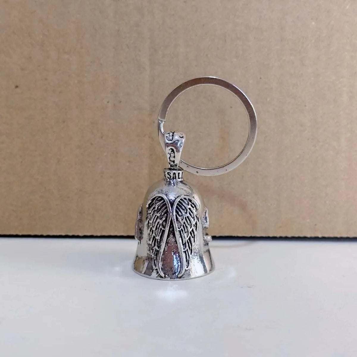 Vintage white angel feather wings alloy keychain and necklace set on a plain background.