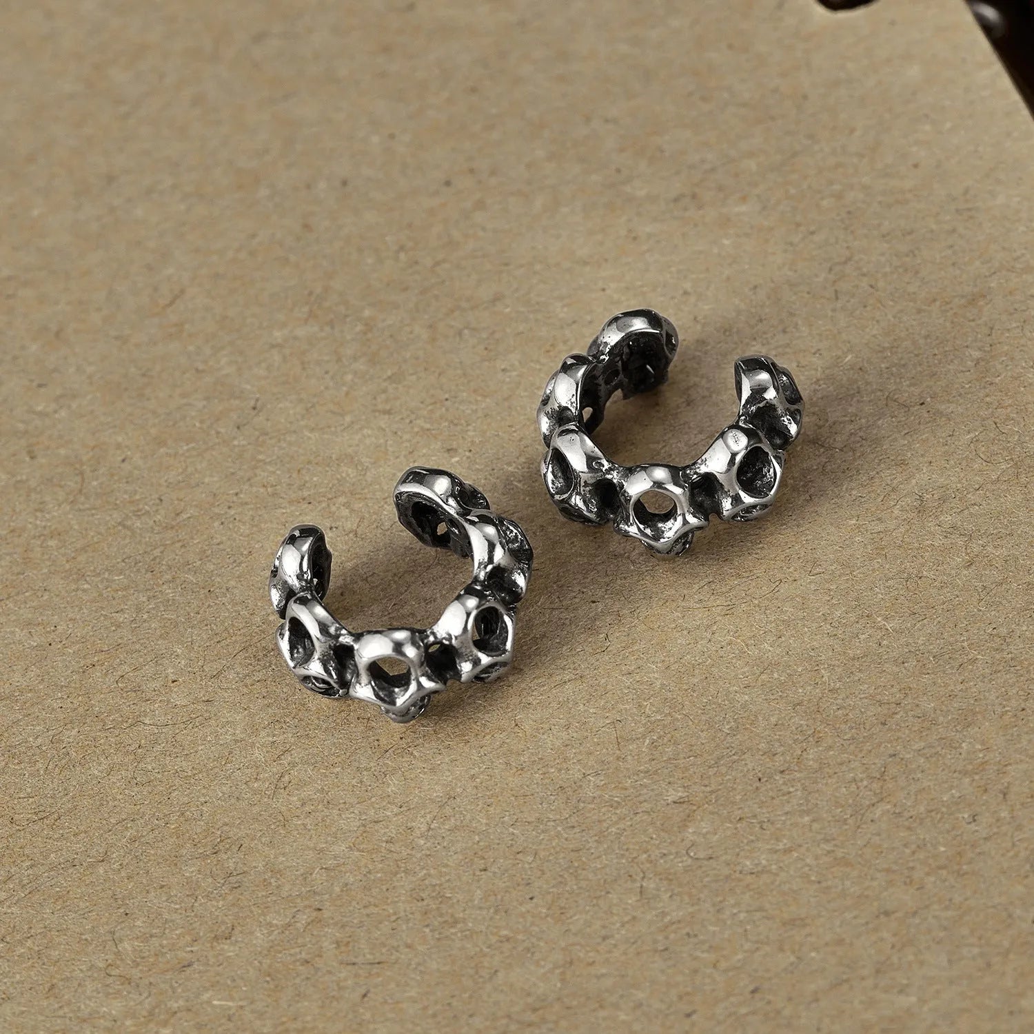Stainless steel skull earrings with hollow geometric design and ear clip fastening