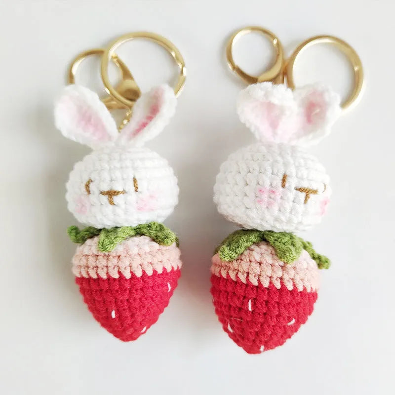 White hand-woven wire pendant charm with a cartoon rabbit and strawberry design on a key hook.