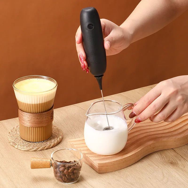 Electric hand-held milk frother in black and white colours for coffee preparation