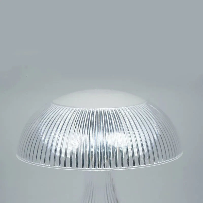 Small white rechargeable touch night lamp with three-colour changing light on wooden table