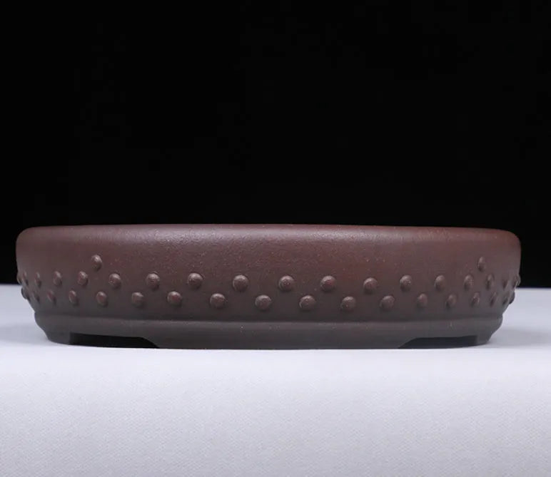 Classical handmade purple clay ceramic flowerpot with large round mouth on a wooden table