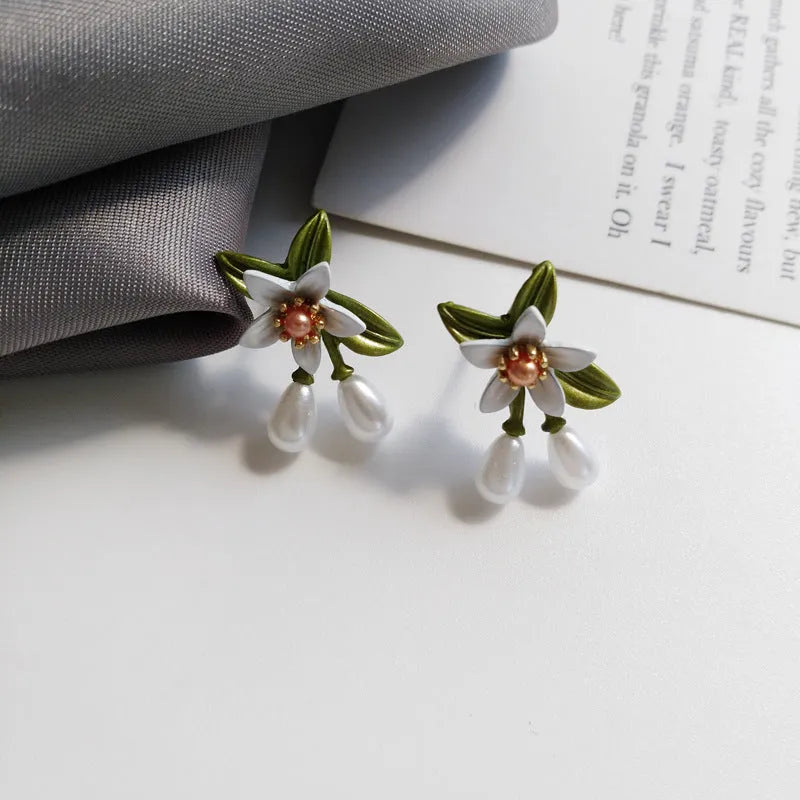 A pair of alloy flower earrings for women, shown in sterling silver needle flowers and flower ear clip styles.