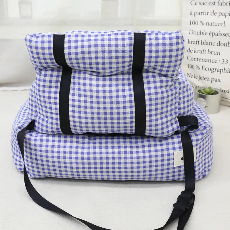 Blue plaid portable dog car bed nest with raised sides, shown on a vehicle seat.