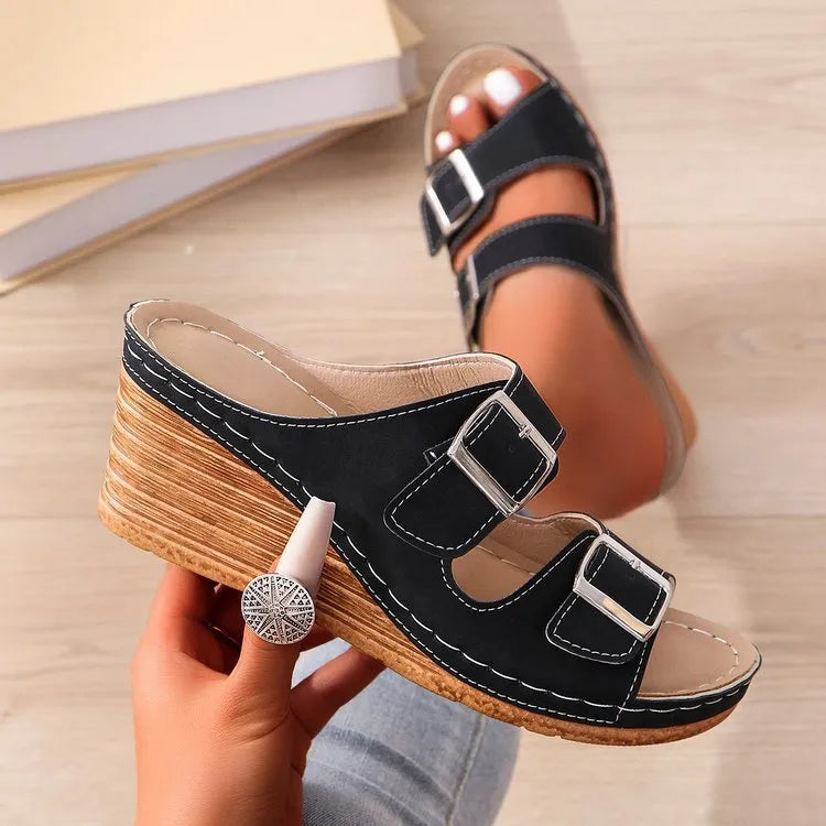 Women's wedge slippers with an outer buckle closure in creamy-white colour on a rubber sole.