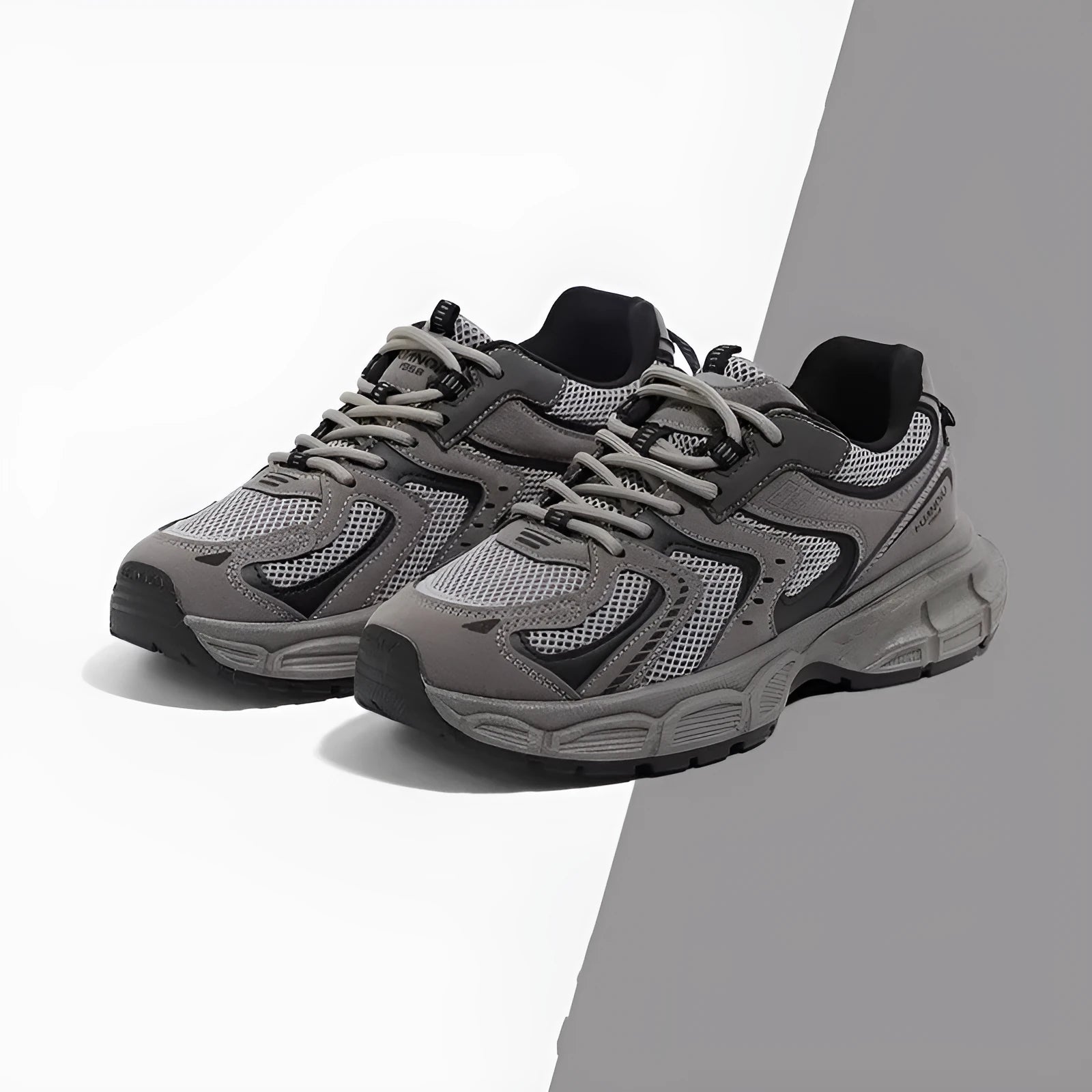 Men's grey low-top platform sneakers with leather stitching on a PU mesh upper and a flat EVA sole.
