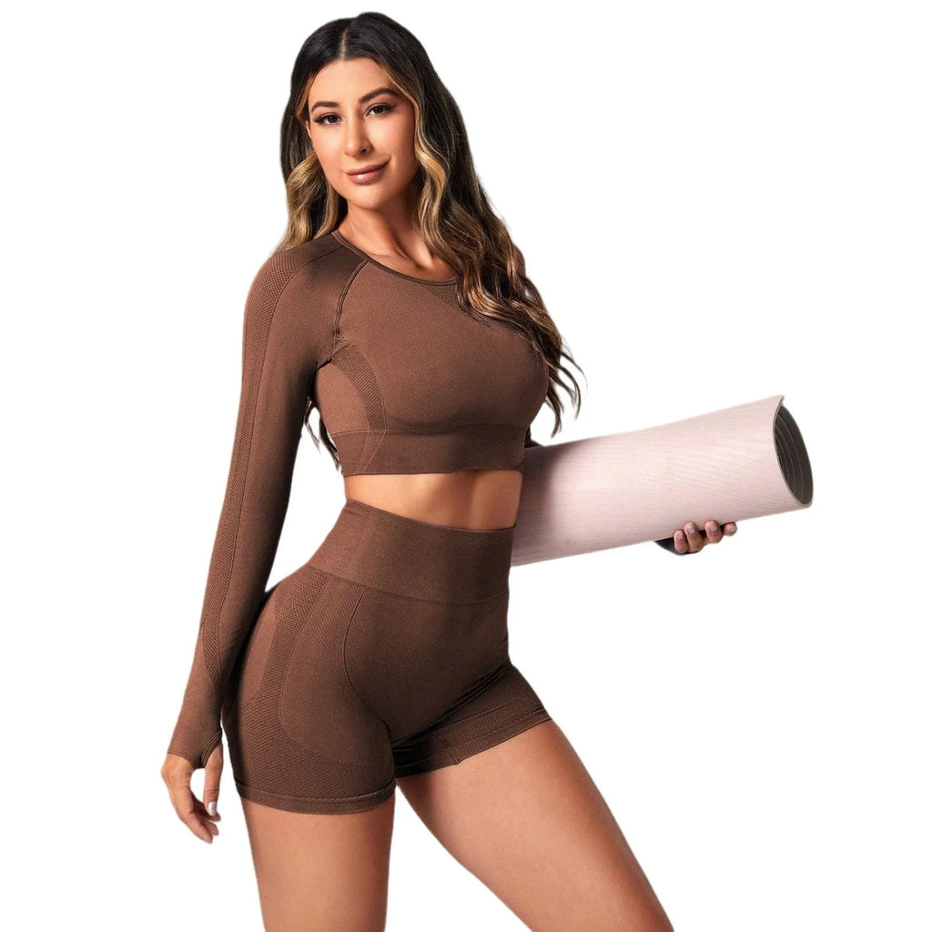 Women's black yoga set comprising a long sleeve top and high-waist trousers laid flat.