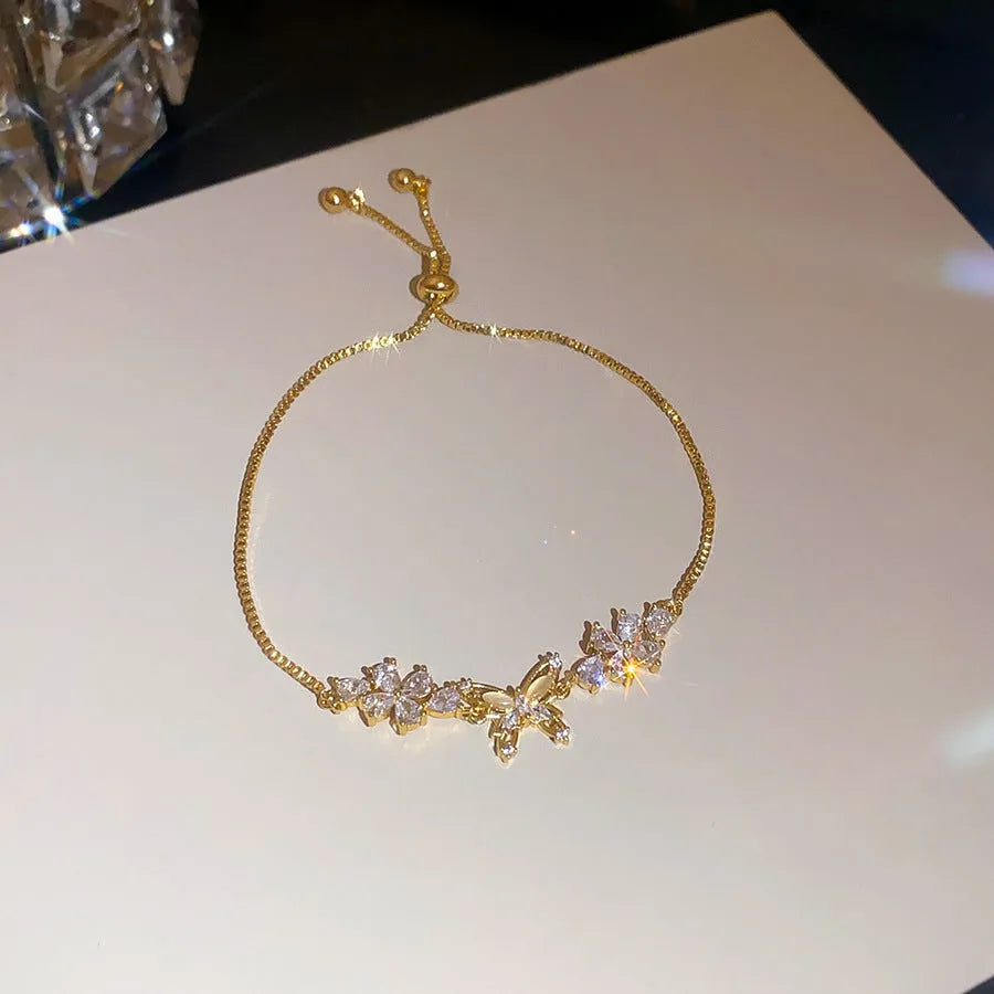 Copper flower butterfly pendant bracelet with inlaid zircon stones gold colour on white background