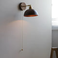 Inn Niche Nordic wooden wall-mounted bedside lamp in walnut colour on a light wall.
