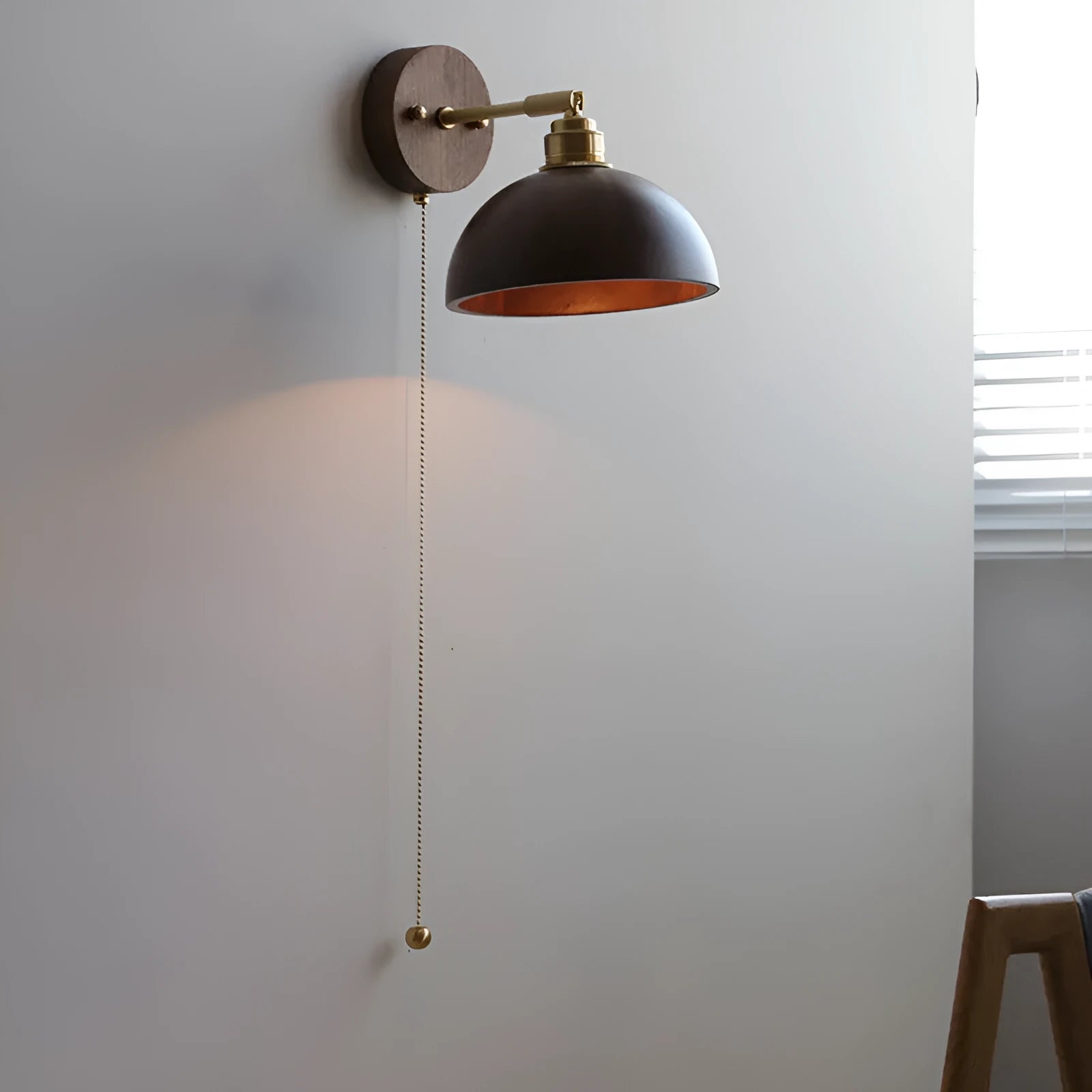 Inn Niche Nordic wooden wall-mounted bedside lamp in walnut colour on a light wall.