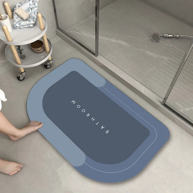 Blended fibre machine woven bathroom floor mat in blue, shown in an oval shape on a tiled floor.