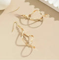 Gold geometric spiral earrings with ellipse elements creating diamond shape design