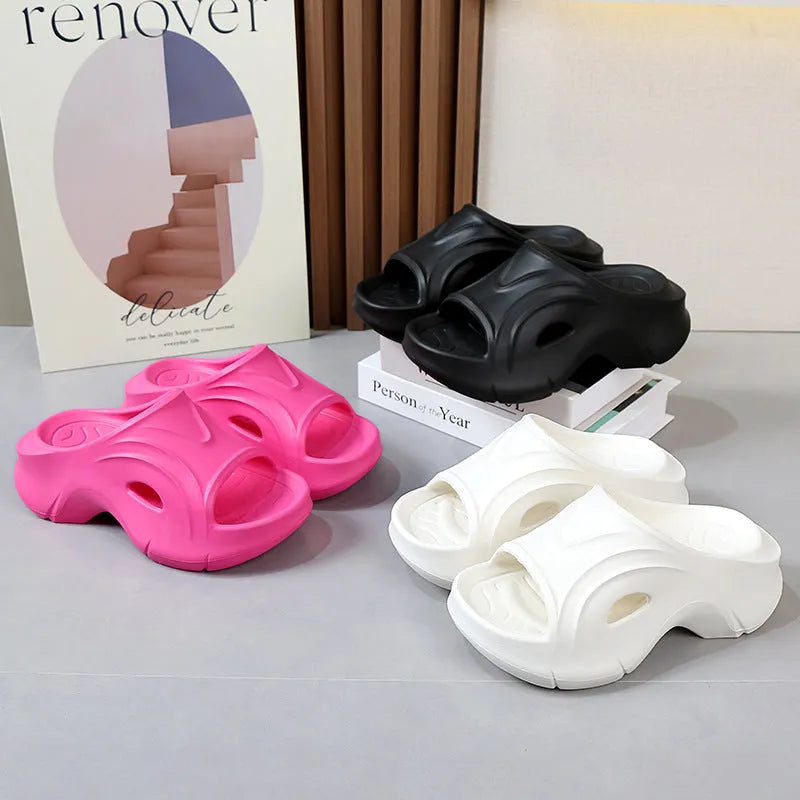 Women's white thick-soled EVA beach slippers with round toe on sand.
