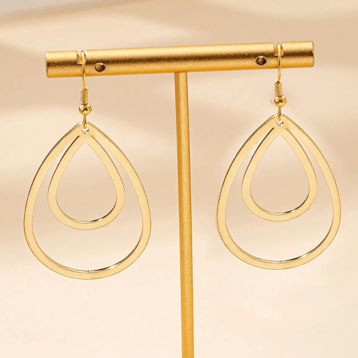 Golden yellow hollow drop earrings made from iron, shown as a pair with an open drop shape