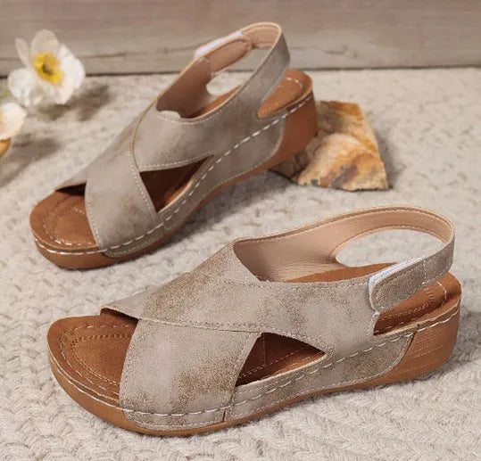 Women's brown Roman sandals with a platform sole, skirt trim detail, and Velcro strap fastening.