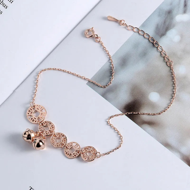 Rose gold stainless steel anklet with coin charms and small bells on adjustable link chain