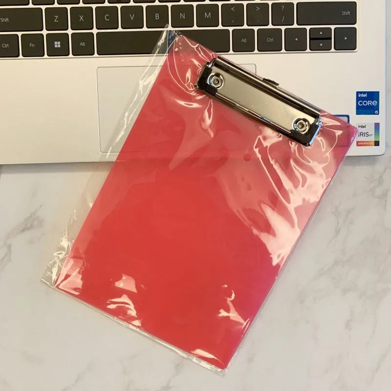 A4 transparent plate holder writing board with metal clip, shown in blue on a desk.