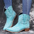 Women's brown cowboy boots with embroidery on the shaft, pointed toe, and a low wedge heel.