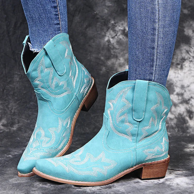 Women's brown cowboy boots with embroidery on the shaft, pointed toe, and a low wedge heel.