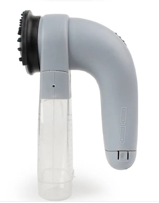 Grey portable pet hair vacuum cleaner with soft rubber grooming head on a fabric sofa
