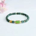 Natural stone blue water jade beaded bracelet with round and oval geometric beads on a white background