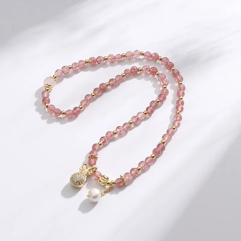 Women's geometric strawberry quartz crystal wallet bracelet on a wrist.