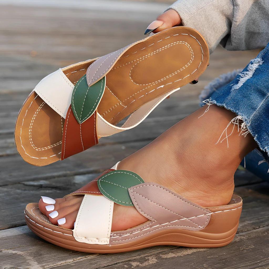 Women's black thick-soled slippers with cross-straps and a peep-toe opening on a white background.