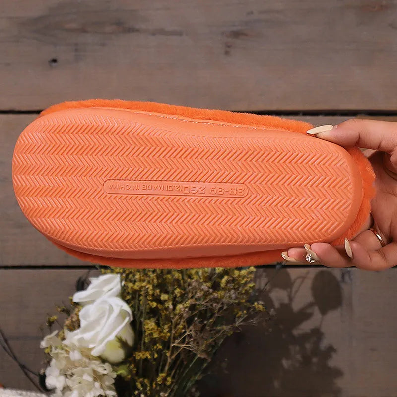 Orange Halloween pumpkin slippers with coral velvet upper and plush lining on a non-slip PVC sole.