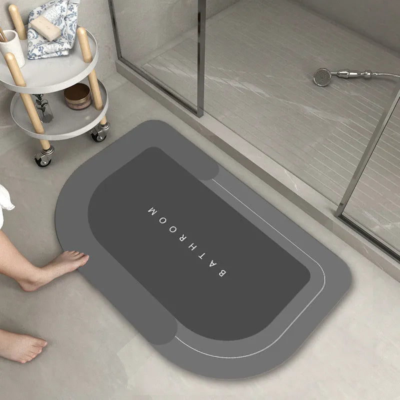 Blended fibre machine woven bathroom floor mat in blue, shown in an oval shape on a tiled floor.