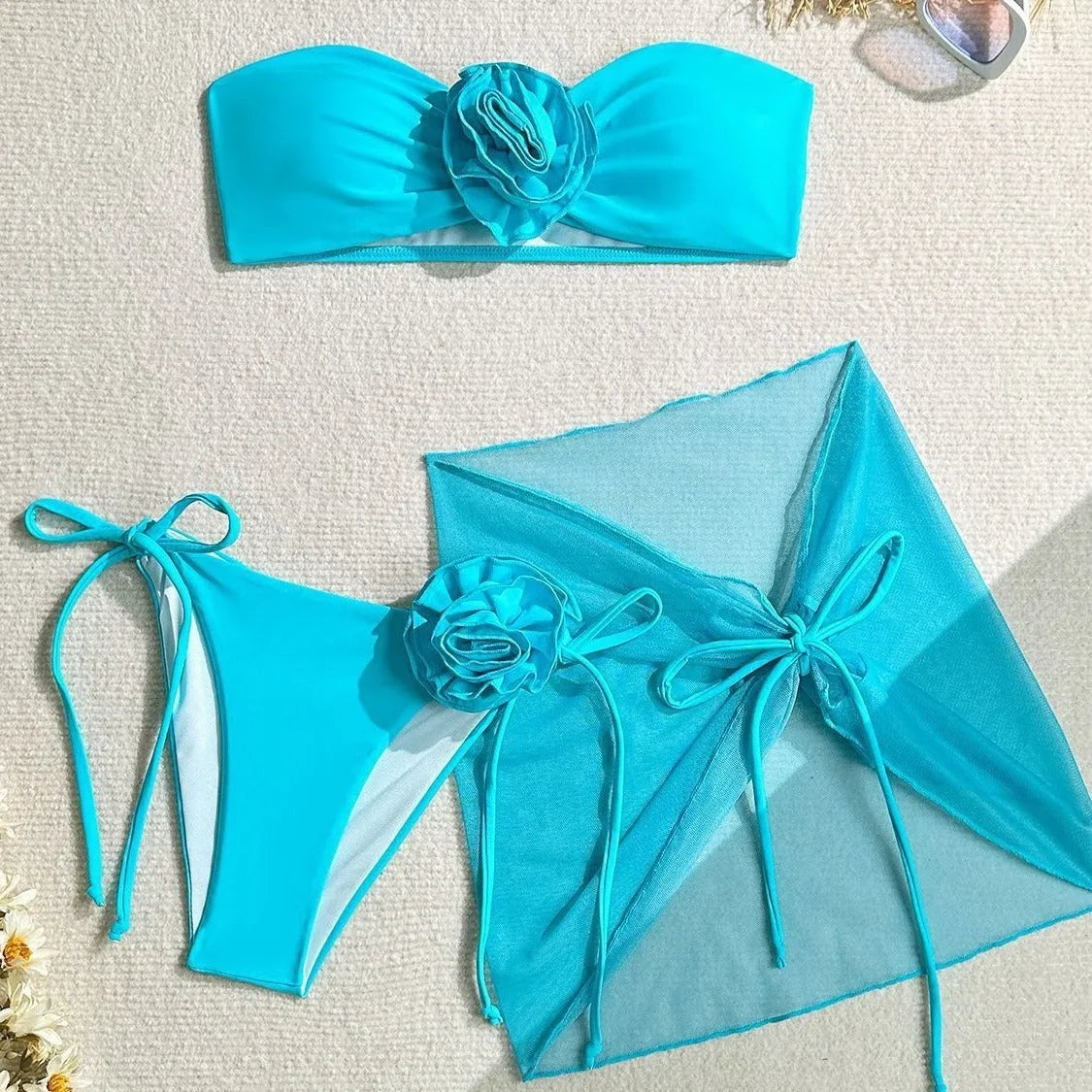 Women's pink swimsuit top with a large 3D flower tie and matching skirt set on a mannequin.