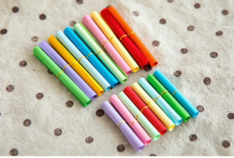 Assorted coloured paper scrolls in small sizes with a metal eyelet for hanging.