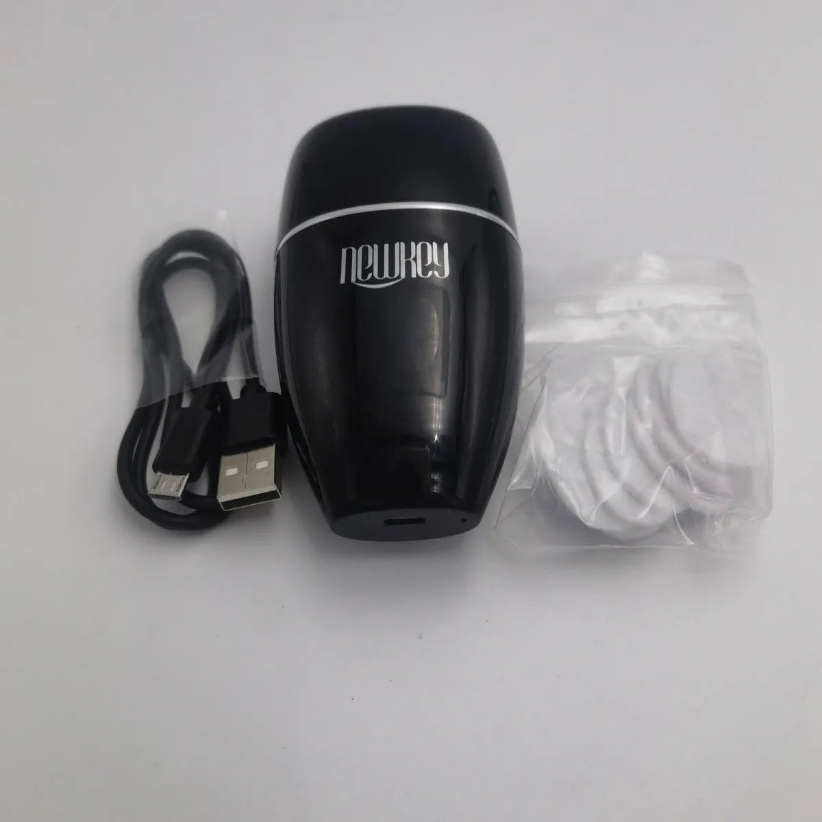 Black and white electric lip plumper device with silicone tip and USB charging cable