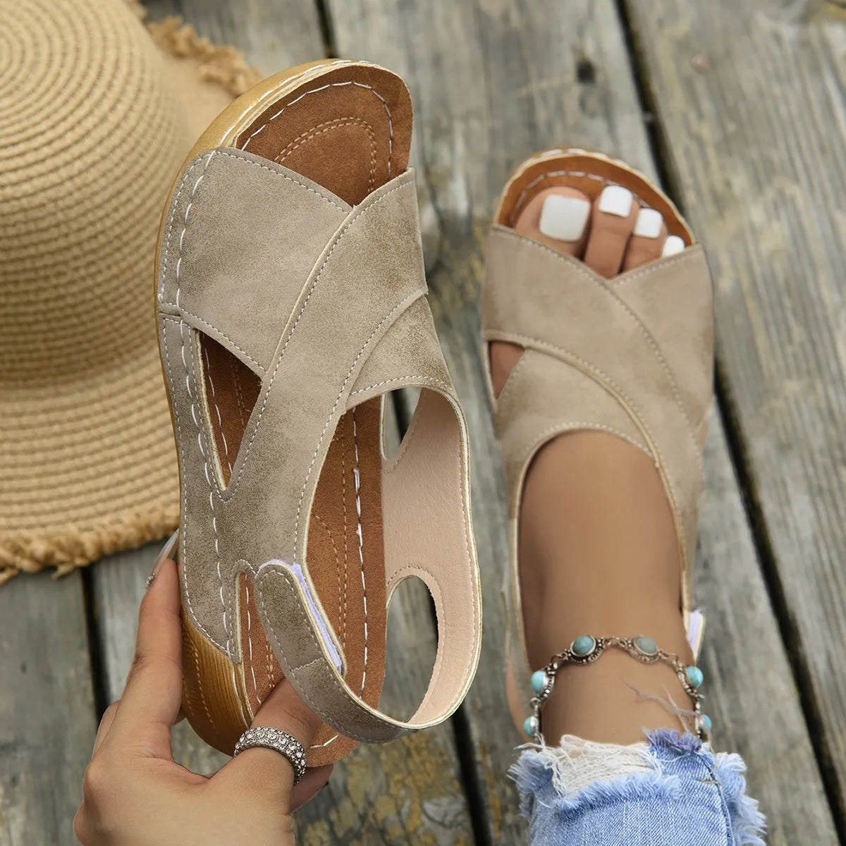 Women's brown Roman sandals with a platform sole, skirt trim detail, and Velcro strap fastening.