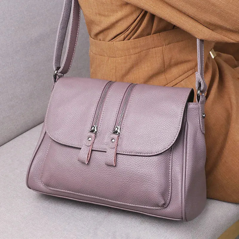 Cowhide leather shoulder handbag with chain and cover closure, 30x19x13cm, shown in wine red or light purple.