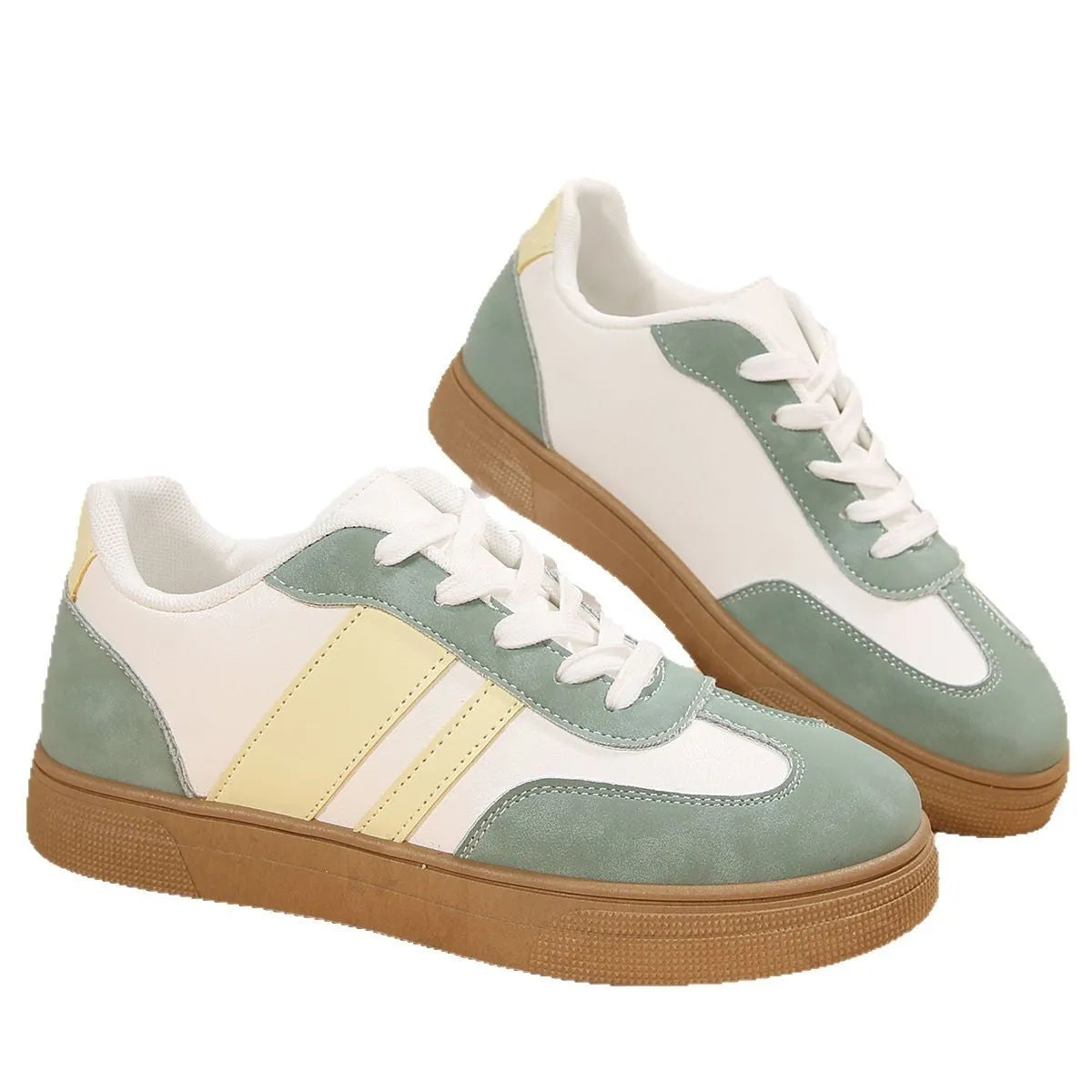 Green women's retro sneakers with cross-strap detail and leather stitching on a white background.
