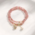 Women's geometric strawberry quartz crystal wallet bracelet on a wrist.