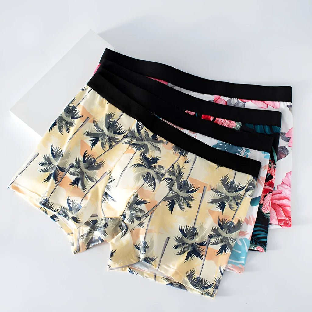 Men's printed ice silk underwear in floral, brown, and seaside designs showing mid waist fit.
