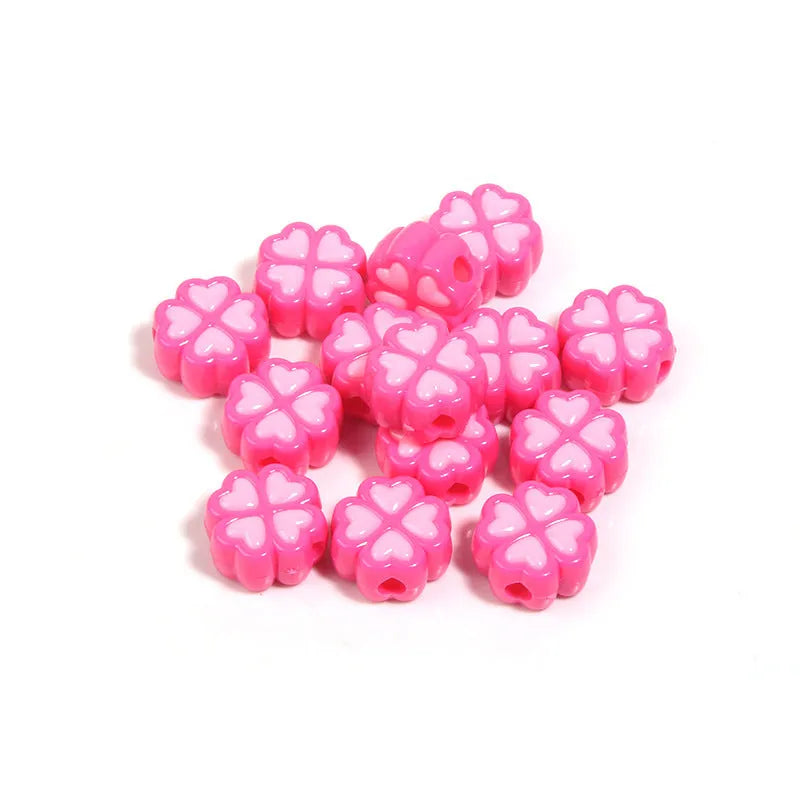 Frosted acrylic four-leaf clover shaped beads in mixed colours on white background
