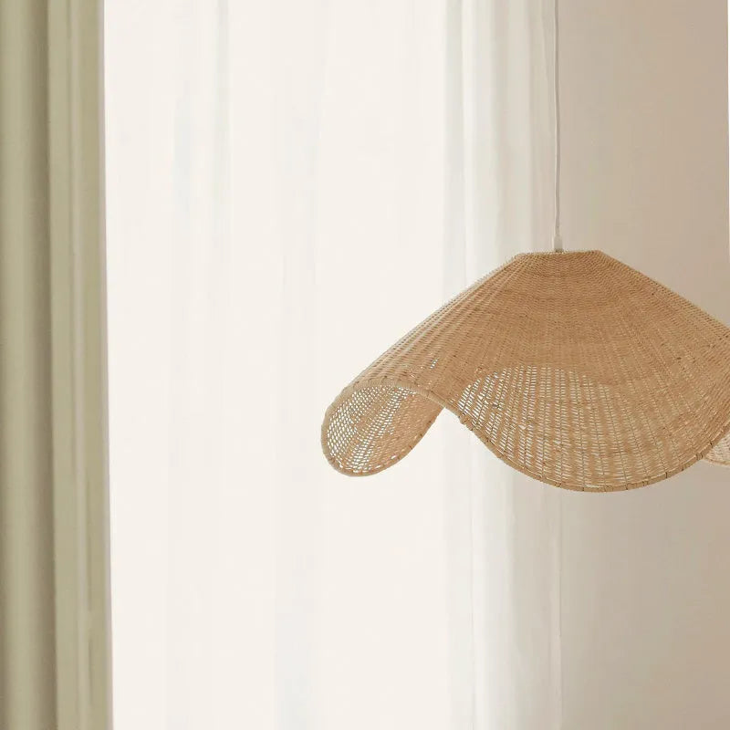 Handmade natural rattan and willow bamboo chandelier with warm LED light in a rustic setting.