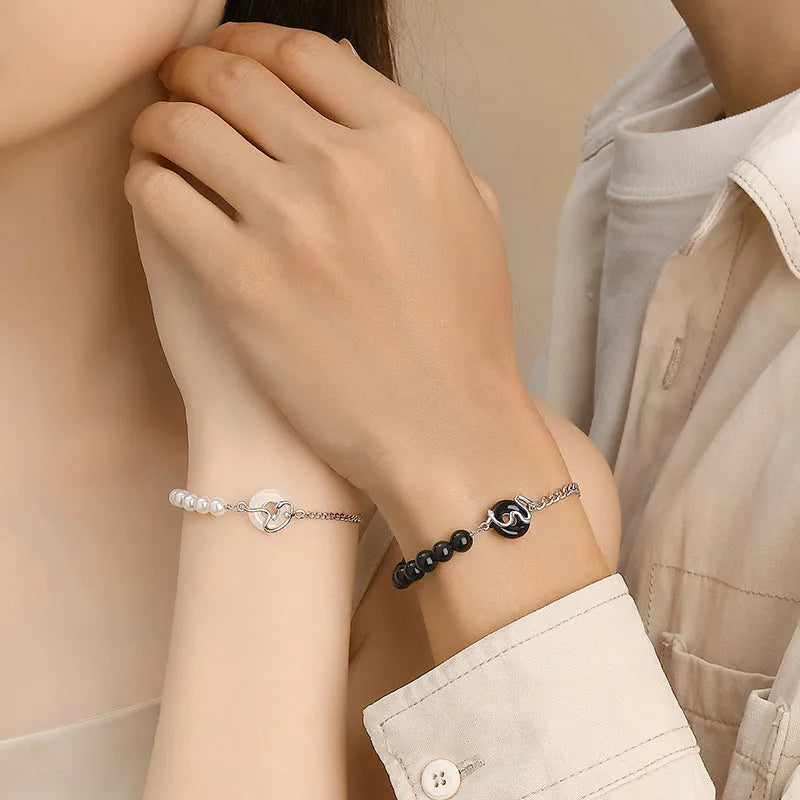 Close-up of a 925 sterling silver bracelet with a safe buckle, featuring obsidian pearls and a detailed snake charm in a new Chinese style.