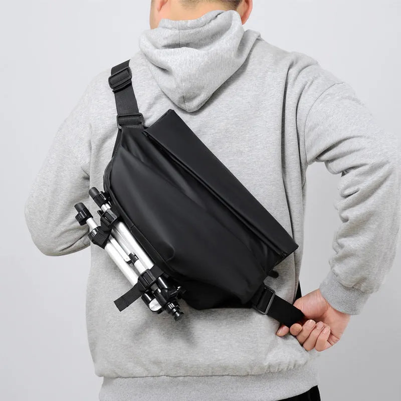 Grey men's medium crossbody bag with shoulder strap showing zipper opening and horizontal square shape