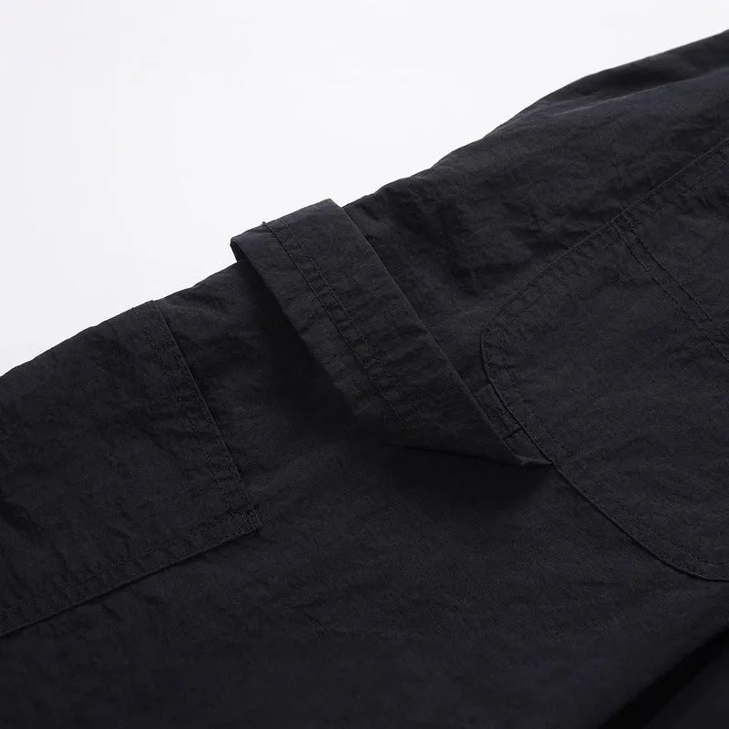 Black men's baggy paratrooper pants with an elastic drawstring waist on a neutral background.